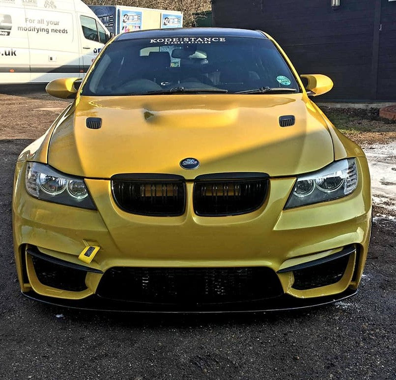 Front view of gold BMW E90 with M4 style bumper and black front lip blade installed