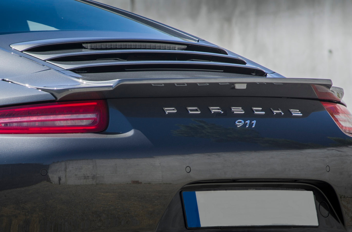Close-up of Porsche 911 991 Phase 1 rear spoiler and logo with body kit.