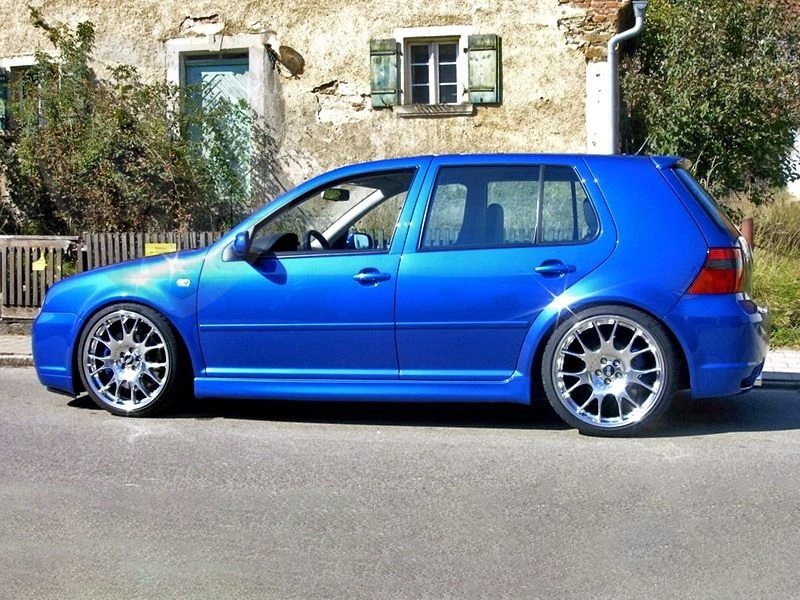 Side view of Volkswagen Golf IV in blue equipped with R32 look side skirts, parked on the street with aftermarket alloy wheels.