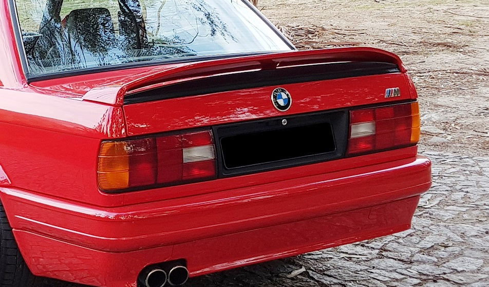 BMW E30 rear close-up with TRUNK SPOILER BMW E30 M-TECH 2, showing spoiler detail above the tail lights and trunk lid