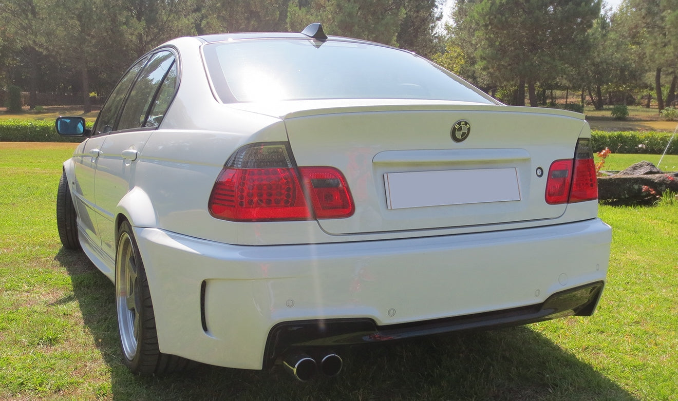 Back view of a rear bumper BMW 3 Series E46 1M Look installed on a white BMW sedan with sporty styling.