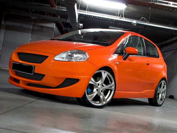 Orange Fiat Grande Punto equipped with Magik side skirts, emphasizing a sporty, aerodynamic design and custom tuning style.