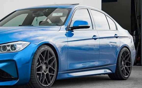 Blue BMW 3 Series F30 fitted with M2 LOOK side skirts, featuring a lowered stance and aerodynamic sporty styling.