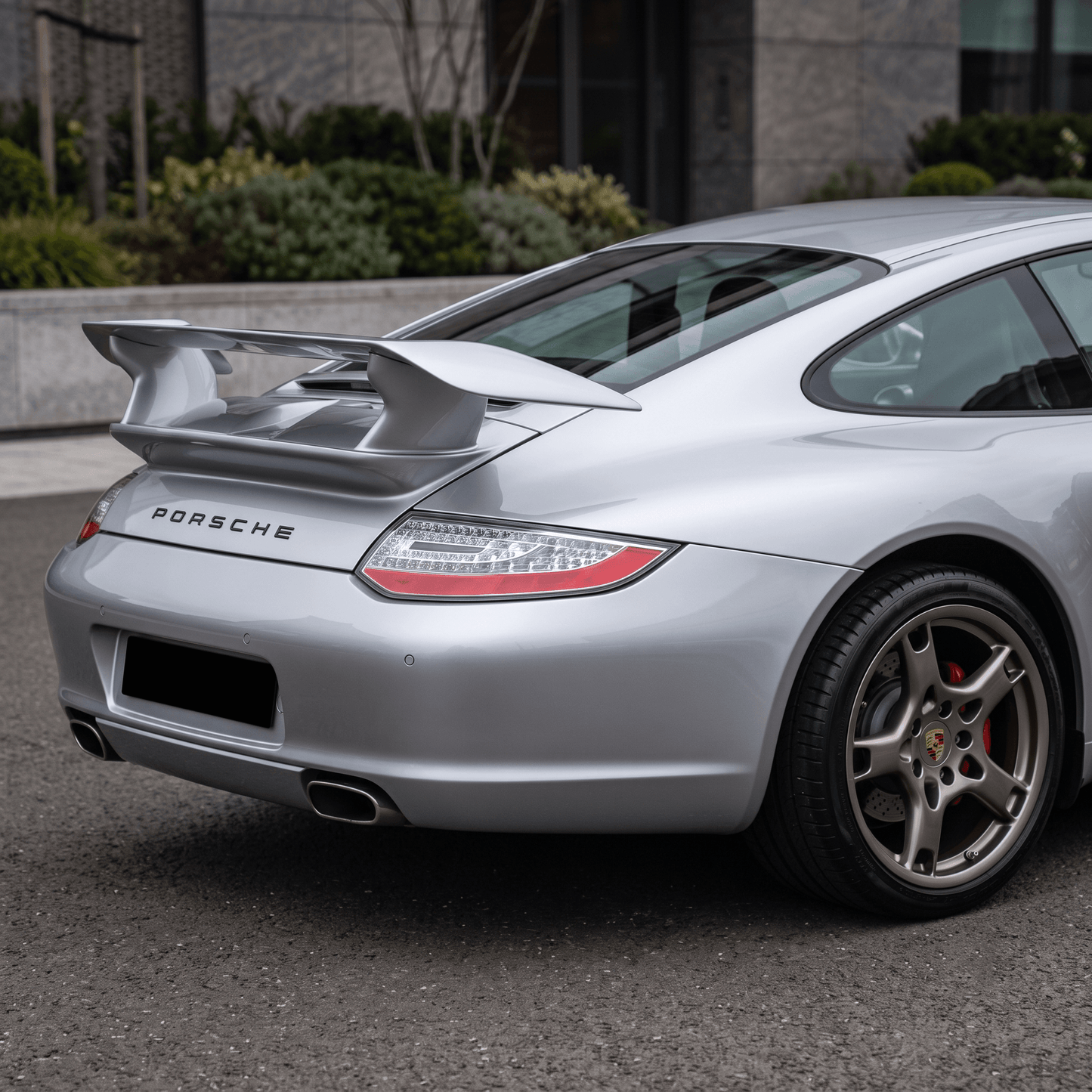 TRUNK SPOILER PORSCHE 911 997 fitted on a silver Porsche 911, shown from the rear three-quarter view