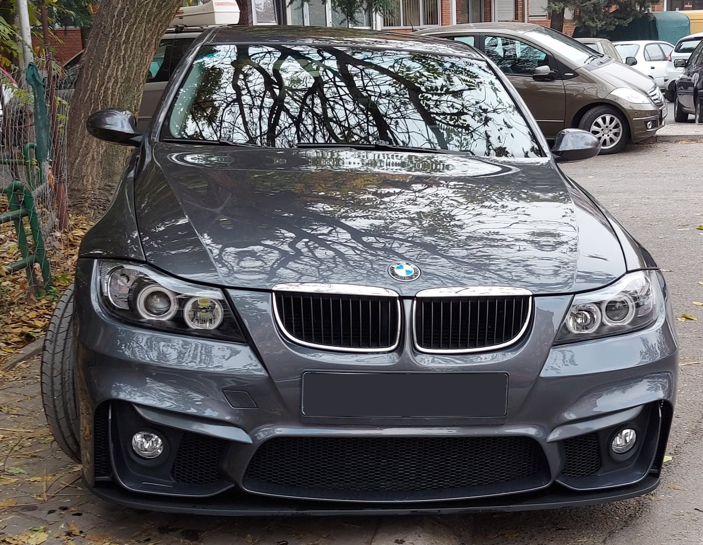 Front view of grey BMW E90 sedan with M4 style bumper and black front blade lip installed