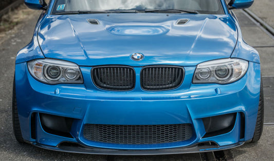 Bonnet BMW 1 Series E81/E82/E87/E88 M1 installed on a blue coupe, featuring aggressive bulge and air vents, matching the M1 look.