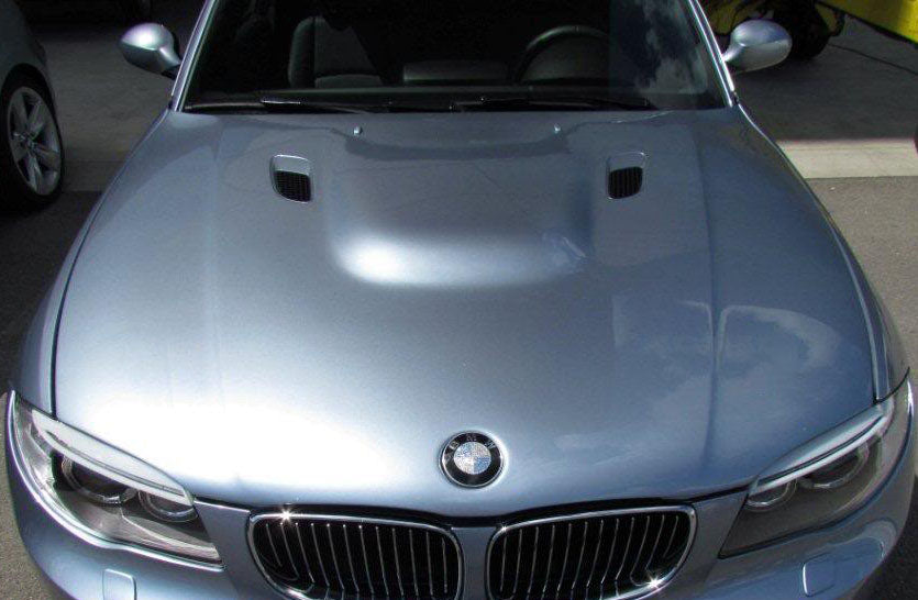 Top view of bonnet BMW 1 Series E81/E82/E87/E88 M1 mounted on a silver vehicle, highlighting its central dome and integrated air vents.