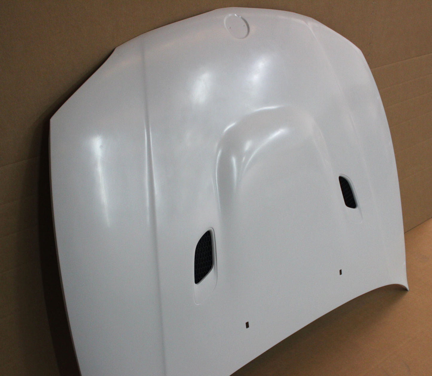 Side perspective of bonnet BMW 1 Series E81/E82/E87/E88 M1 in raw finish, showing vent placement and contours.