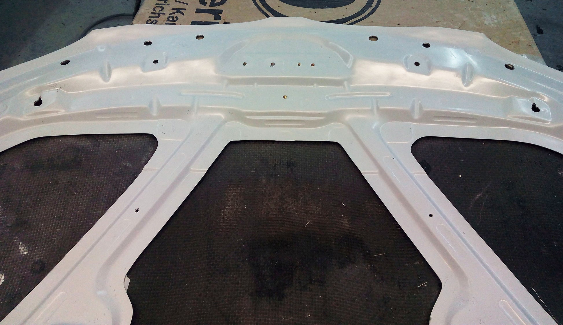 Underside of bonnet BMW 1 Series E81/E82/E87/E88 M1, highlighting the full structural frame and pre-drilled mounting holes.