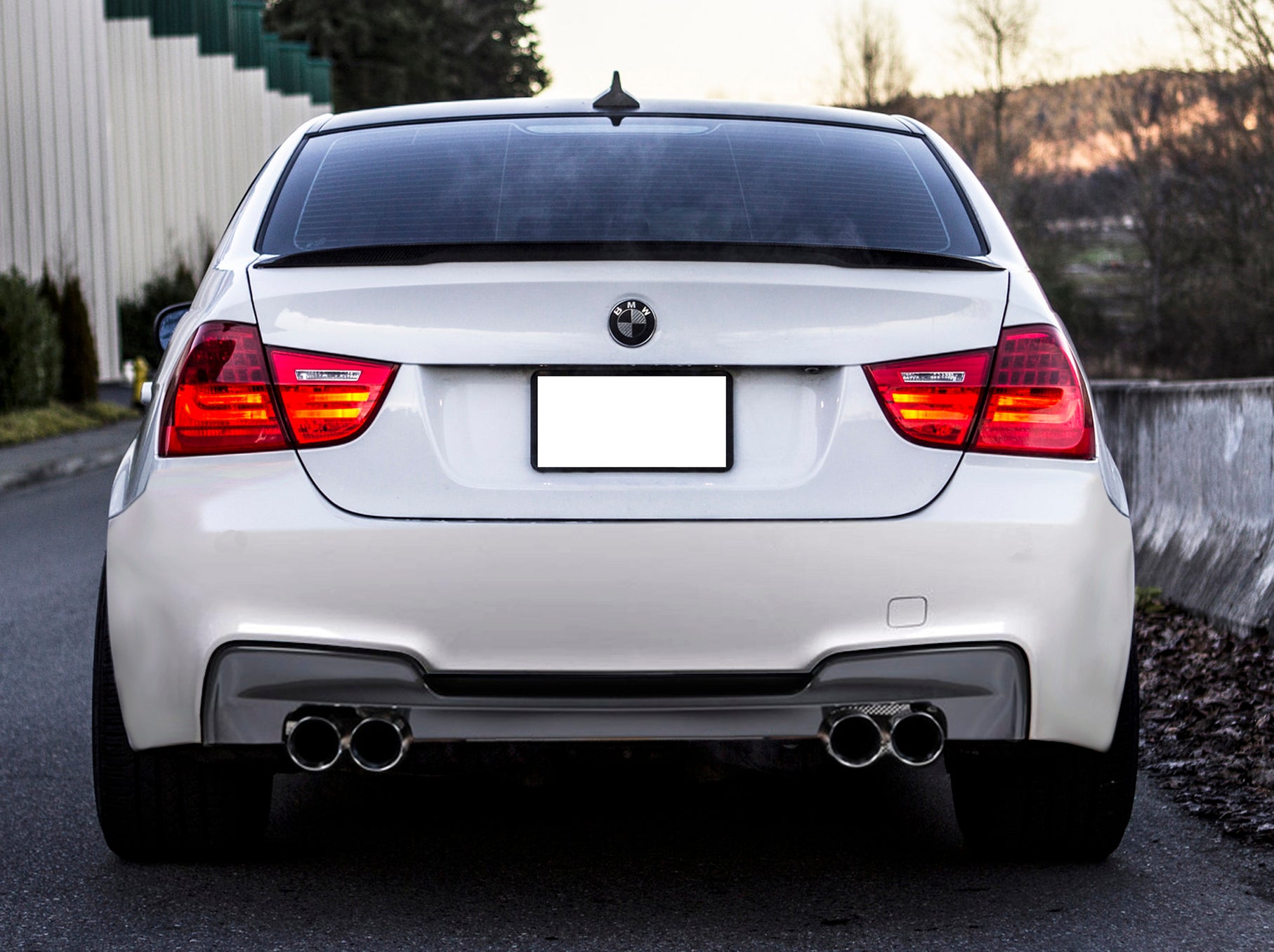 Back View of Rear Bumper for BMW 3 Series E90 1M Look & Rear Diffuser 1M Look Double Exhaust Left Side on vehicle. Made from 1st grade FRP (reinforced fiberglass)