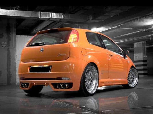 Orange Fiat Grande Punto equipped with a custom rear bumper featuring quad exhaust outlets, a central diffuser, and sporty aerodynamic styling.